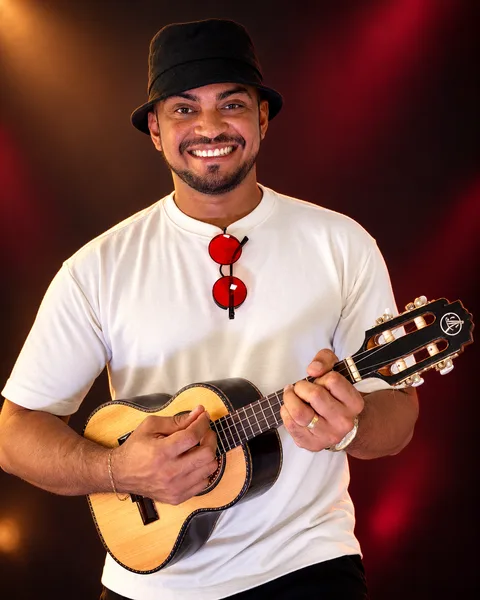Peagá — chapéu, camiseta clara e instrumento